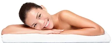 femme blanche et brune souriant allongée sur un lit femme blanche et brune souriant allongée sur un lit