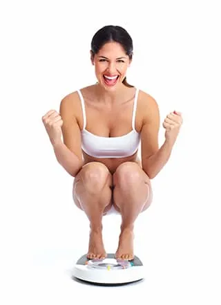 femme blanche souriant sur un pese personne et un fond blanc femme blanche souriant sur un pese personne et un fond blanc