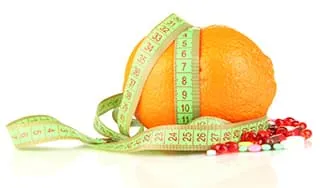 orange entourée d'un metre ruban et de gelules sur un fond blanc orange entourée d'un metre ruban et de gelules sur un fond blanc